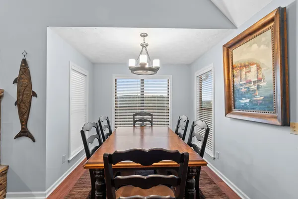 a dining room with furniture a chandelier and wooden floor
