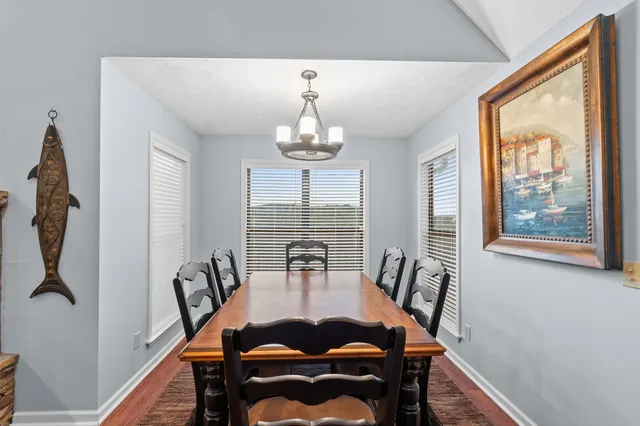 a dining room with furniture a chandelier and wooden floor