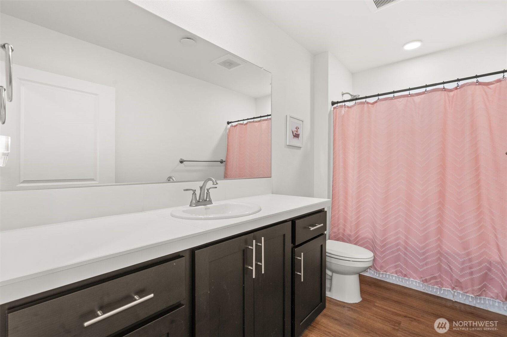 501 Pagget Avenue Winlock, WA 98596 - Photo 21 of 30 a bathroom with a granite countertop sink a toilet a mirror and shower curtain