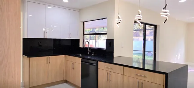 a view of a kitchen with refrigerator and a stove