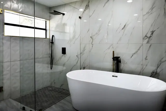 a white bath tub sitting next to a white sink and a shower