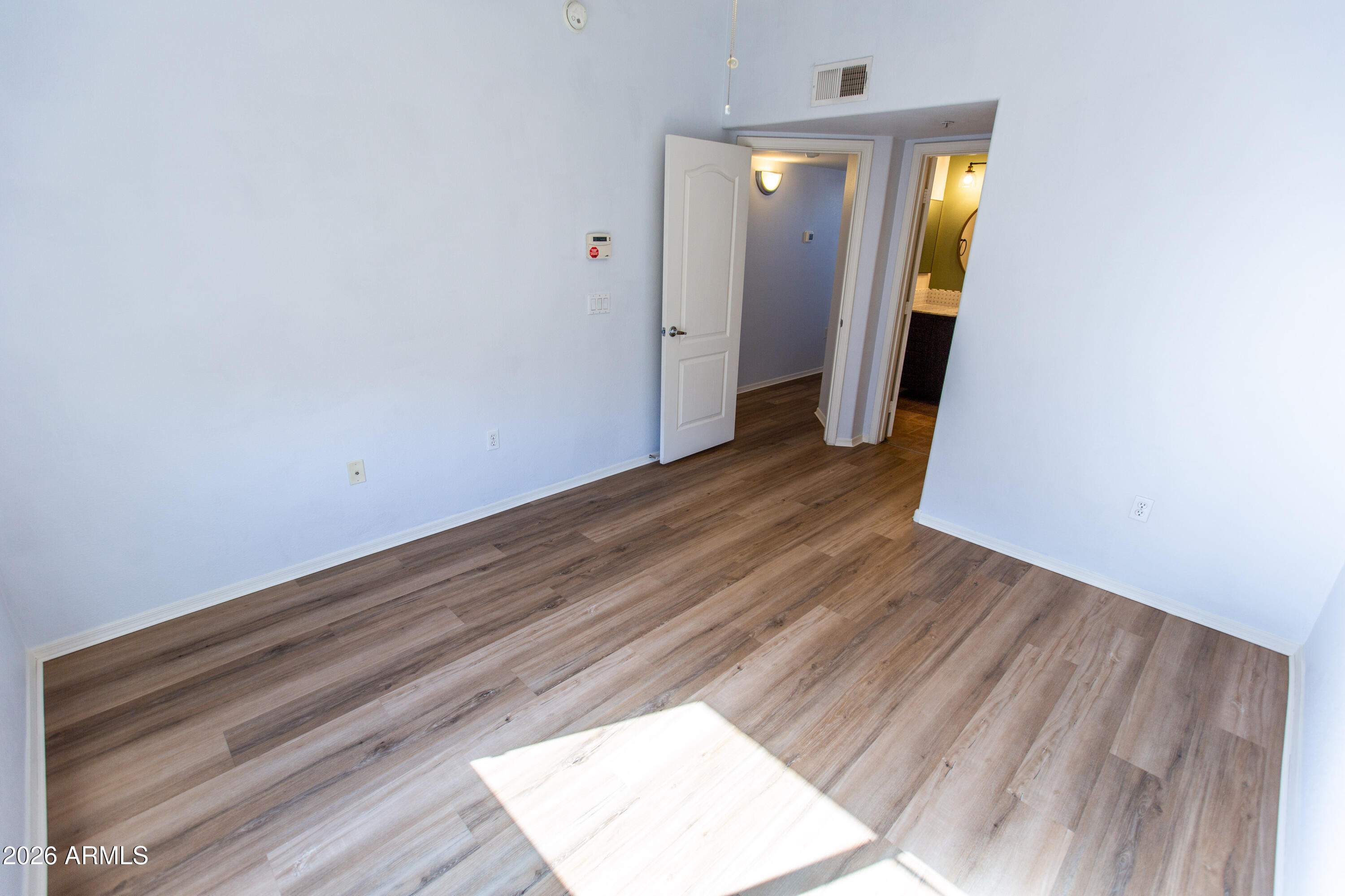 280 South Evergreen Road, Unit 1317 Tempe, AZ 85288 - Photo 29 of 33 an empty room with wooden floor and windows