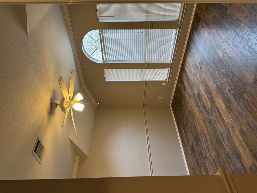 8724 Barrow Glen Loop Austin, TX 78749 - Photo 11 of 19 an empty room with wooden floor and windows