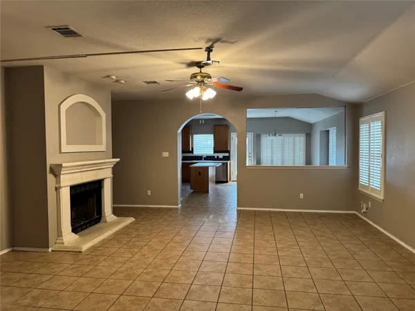 a view of livingroom with kitchen fireplace and a ceiling fan