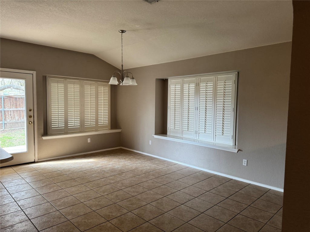 8724 Barrow Glen Loop Austin, TX 78749 - Photo 4 of 19 a view of an empty room with window and cabinet area
