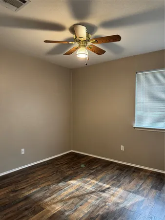a view of a room with wooden floor and fan