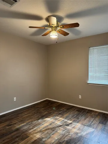 a view of a room with wooden floor and fan