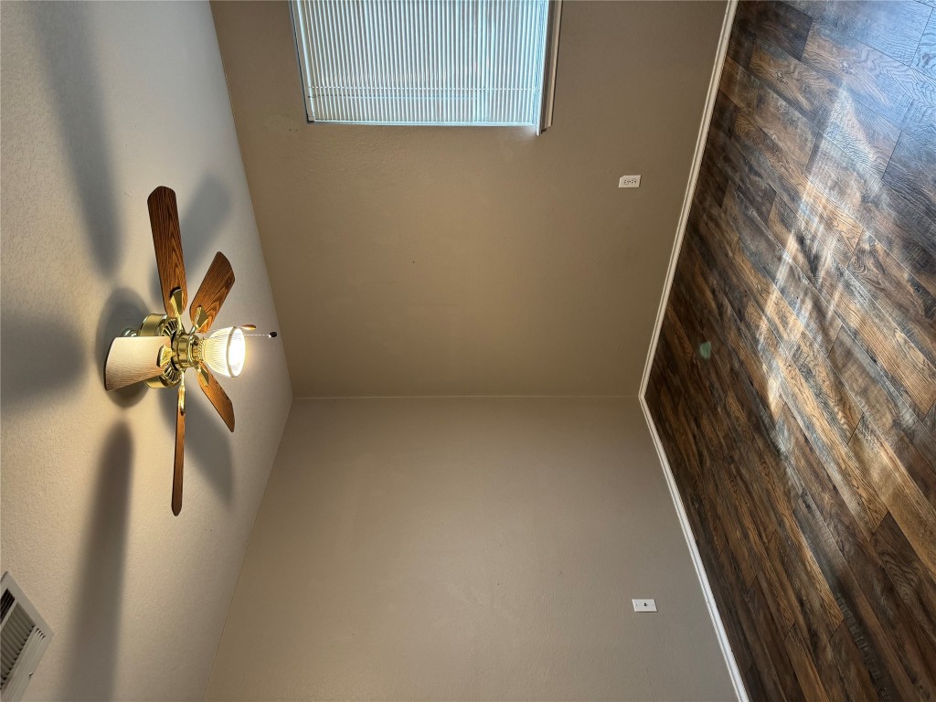 8724 Barrow Glen Loop Austin, TX 78749 - Photo 8 of 19 a view of a room with wooden floor and fan