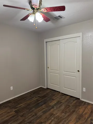 a view of a room with wooden floor closet and fan