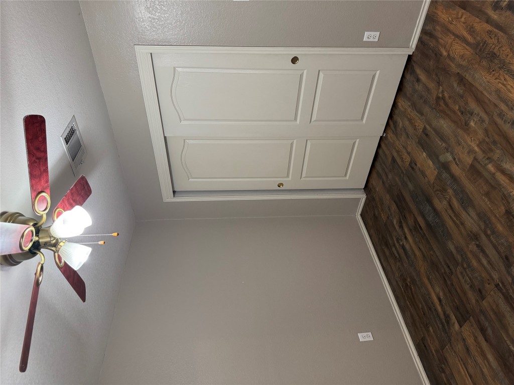 8724 Barrow Glen Loop Austin, TX 78749 - Photo 10 of 19 a view of a room with wooden floor closet and fan