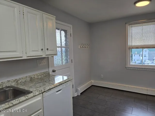 a kitchen with granite countertop white cabinets and a sink