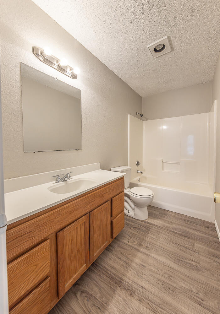 804 East 77th Street Lubbock, TX 79404 - Photo 12 of 15 a bathroom with a double vanity sink a toilet and a large mirror