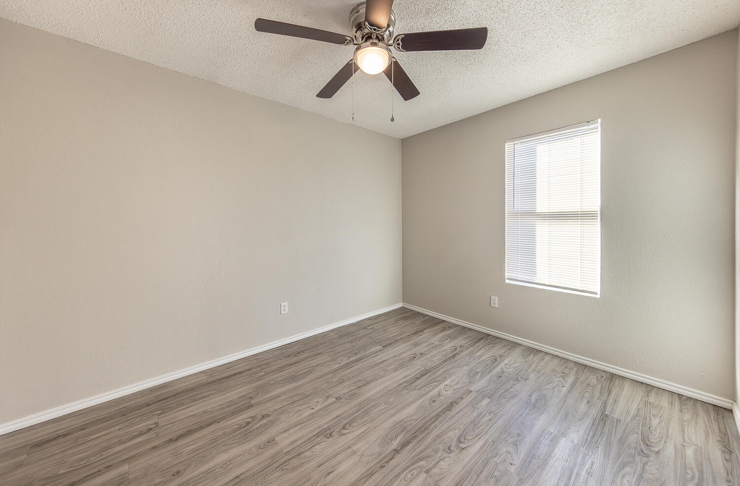 804 East 77th Street Lubbock, TX 79404 - Photo 13 of 15 an empty room with wooden floor ceiling fan and windows