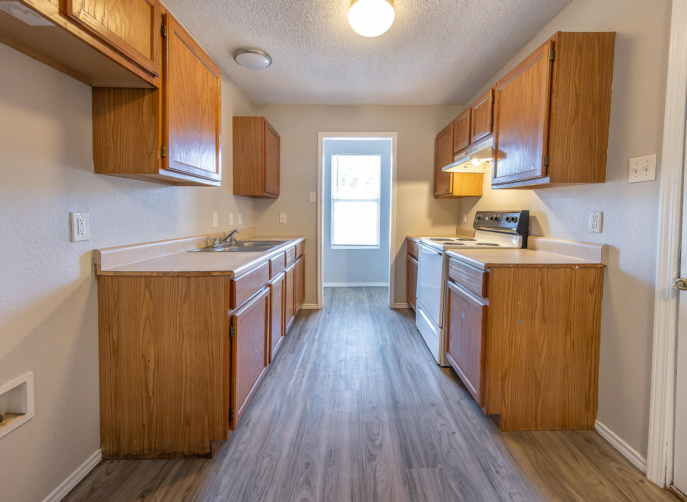 804 East 77th Street Lubbock, TX 79404 - Photo 6 of 15 a kitchen with a sink and wooden cabinets