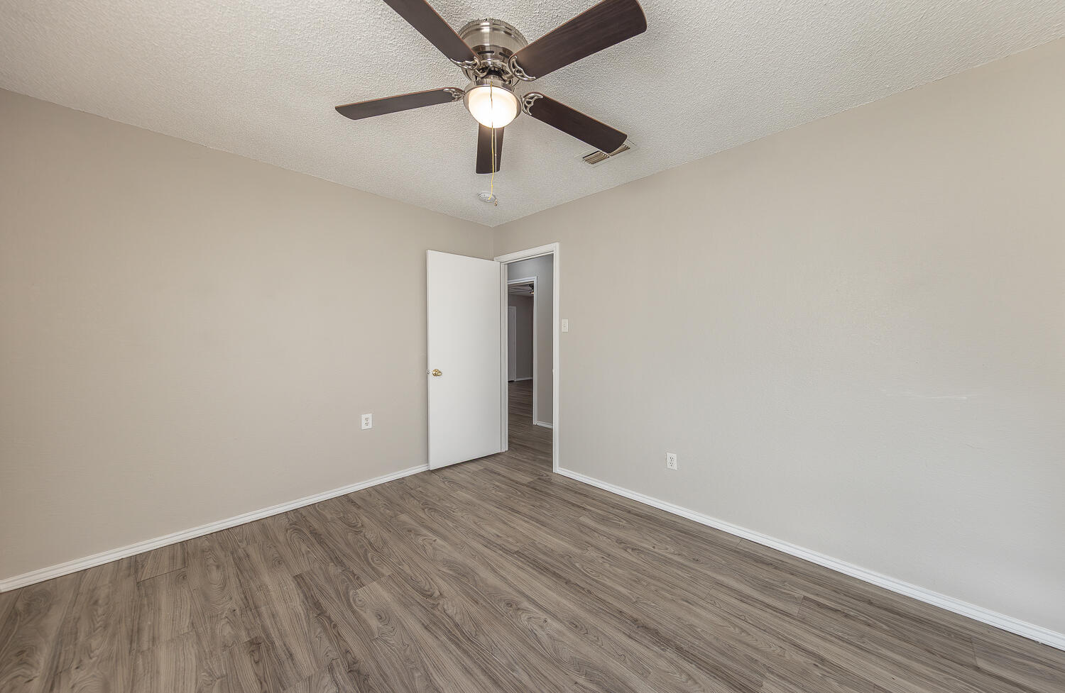 804 East 77th Street Lubbock, TX 79404 - Photo 8 of 15 an empty room with wooden floor and ceiling fan