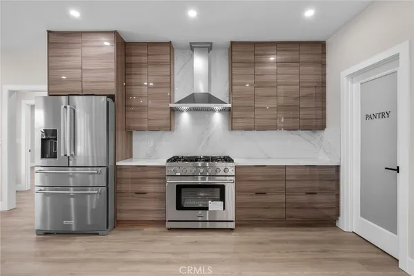 a kitchen with stainless steel appliances granite countertop a refrigerator a stove and a wooden floors