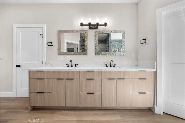 a spacious bathroom with a double vanity sink a mirror and a shower