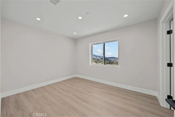 a view of a room with wooden floor and window
