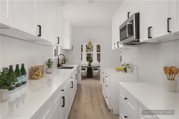 a kitchen with cabinets a sink and wooden floor