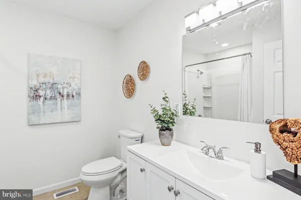 a bathroom with a sink mirror vanity and toilet