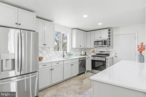 a kitchen with stainless steel appliances granite countertop a refrigerator sink and stove