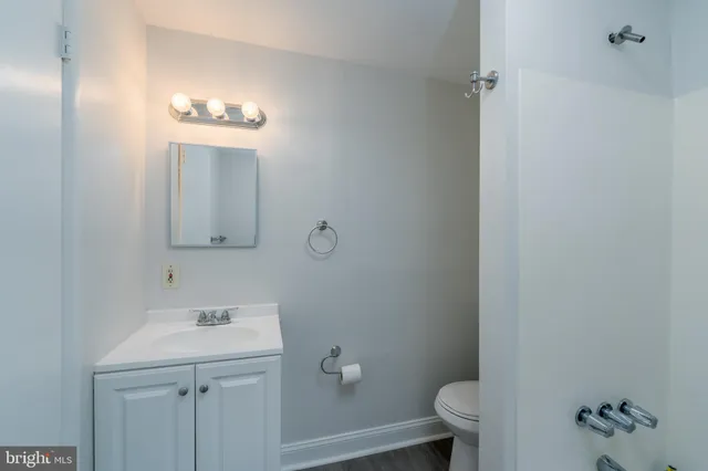 a bathroom with a toilet a sink and mirror