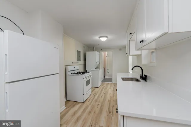 a kitchen with stainless steel appliances a refrigerator sink and white cabinets