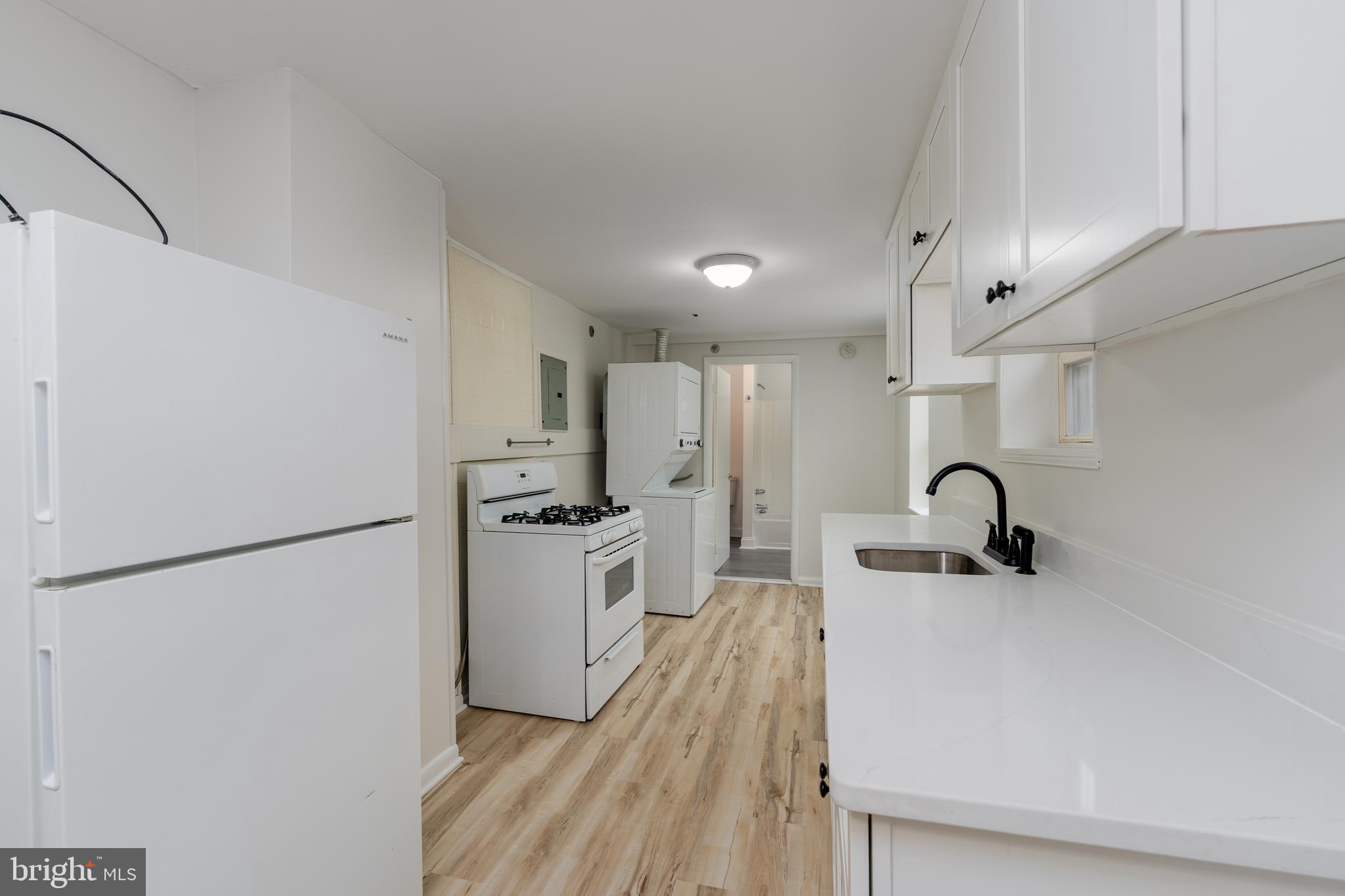 1722 Eastern Avenue, Unit 3 Baltimore, MD 21231 - Photo 5 of 13 a kitchen with stainless steel appliances a refrigerator sink and white cabinets