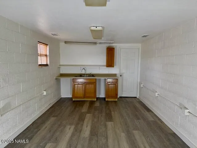 a view of a kitchen with a sink wooden floor and cabinets