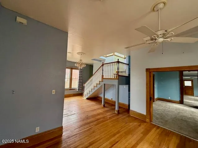 a view of a room with wooden floor staircase and a kitchen