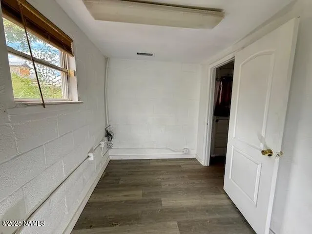 a view of a hallway with wooden floor and cabinet