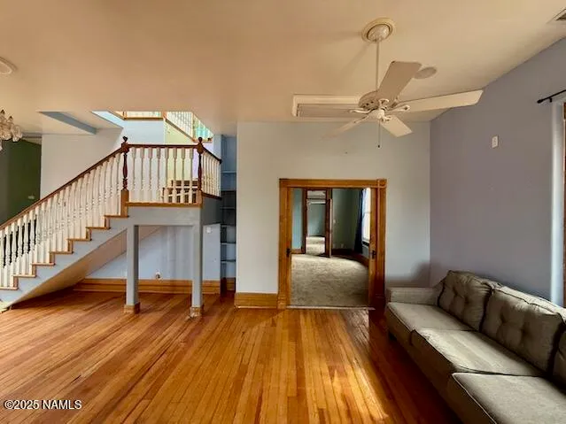 a view of a livingroom with furniture wooden floor windows and a chandelier