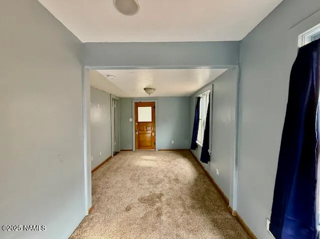 an empty room with mirror and stairs