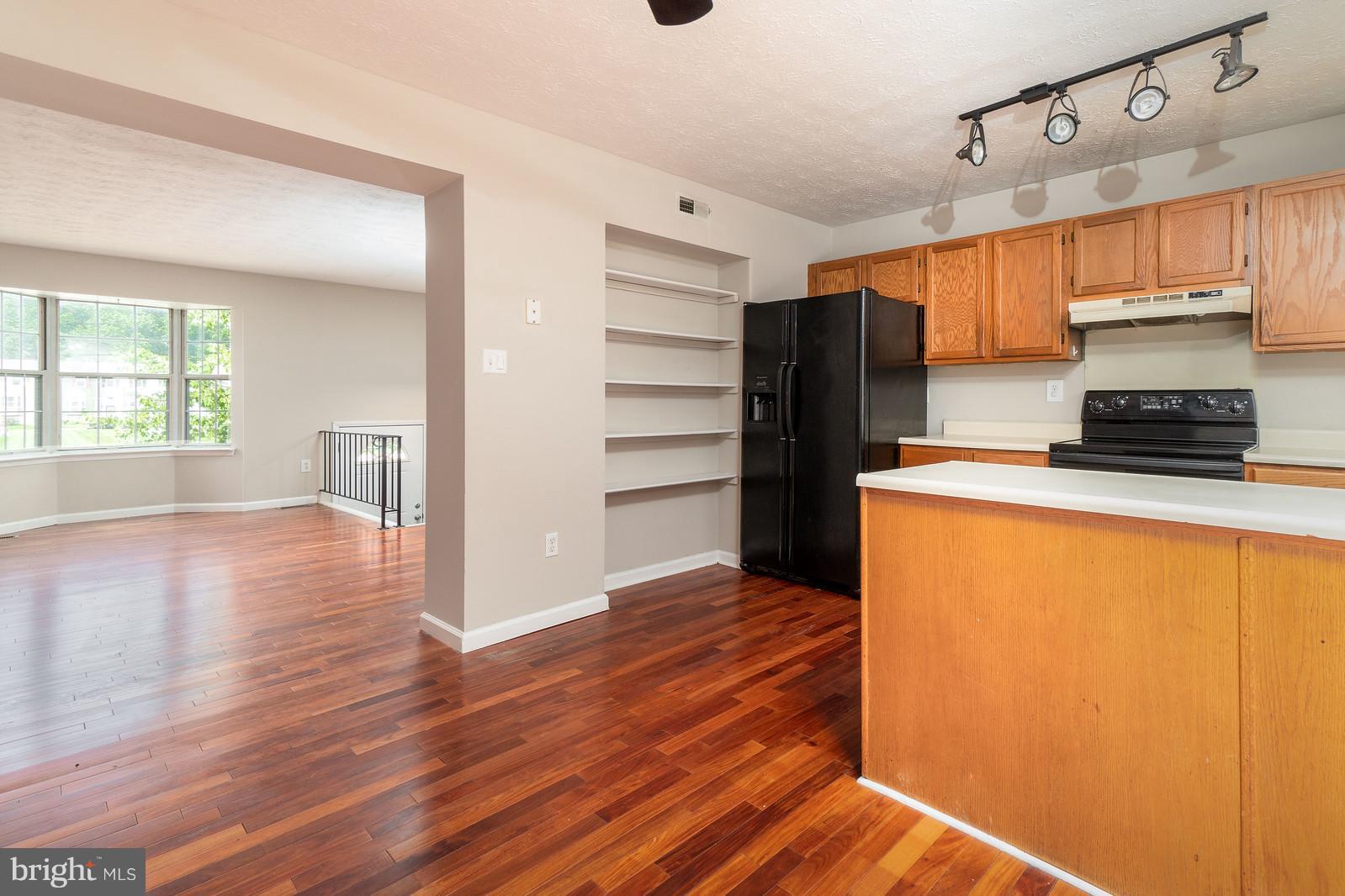 4083 Rustico Road Baltimore, MD 21220 - Photo 12 of 25 a kitchen with granite countertop wooden floors and appliances