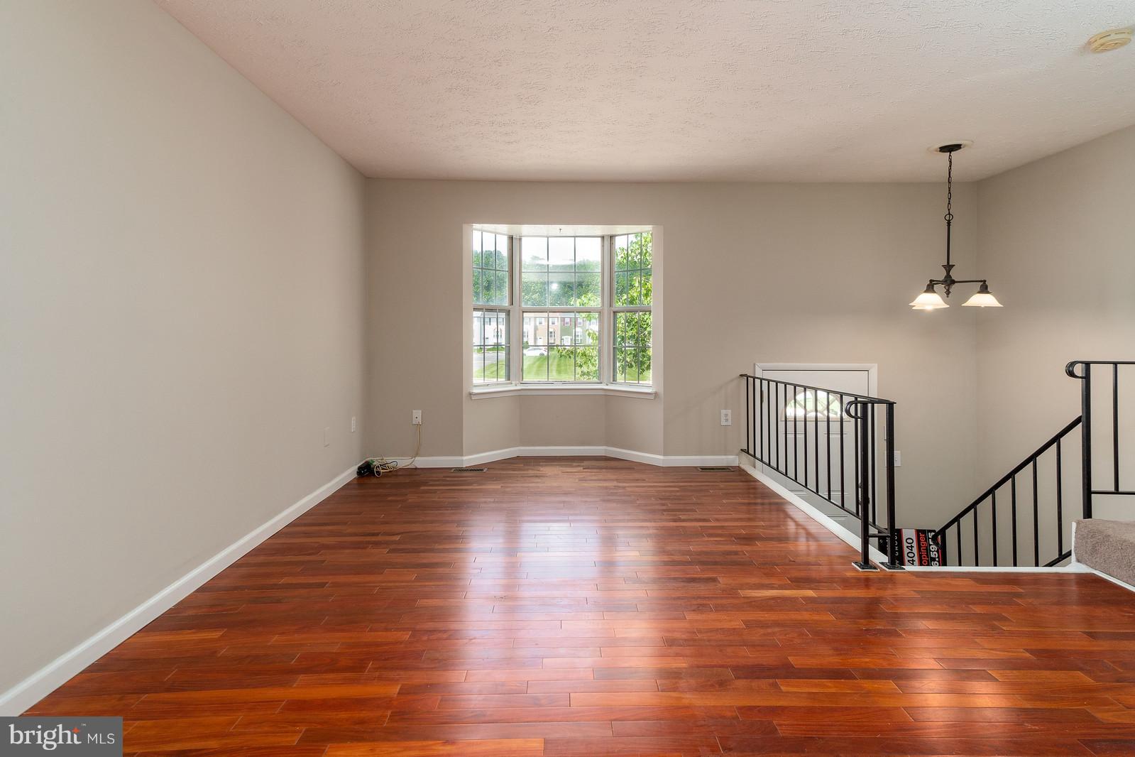 4083 Rustico Road Baltimore, MD 21220 - Photo 5 of 25 a view of an empty room with wooden floor and a window