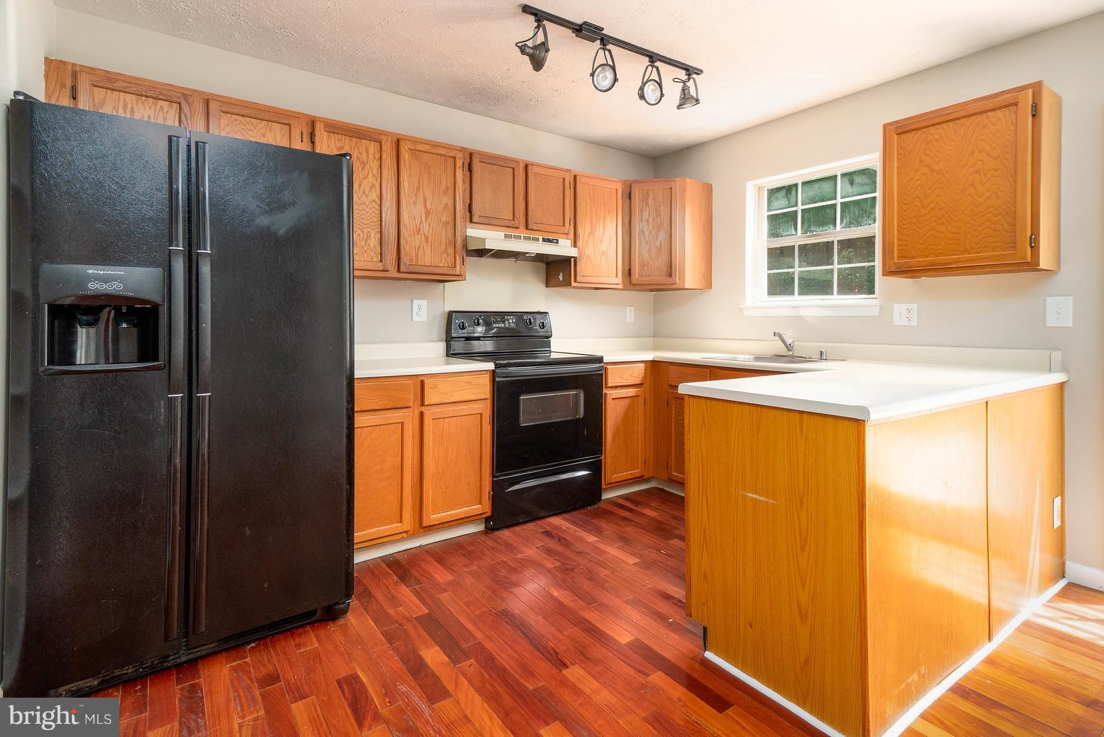 4083 Rustico Road Baltimore, MD 21220 - Photo 9 of 25 a kitchen with stainless steel appliances granite countertop a refrigerator a sink dishwasher a stove with wooden cabinets and floor