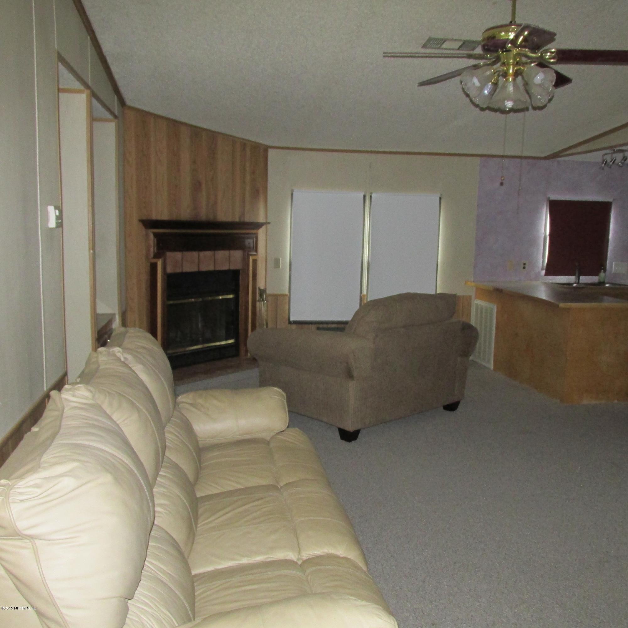 6841 Deer Springs Road Keystone Heights, FL 32656 - Photo 6 of 27 a living room with furniture and a fireplace
