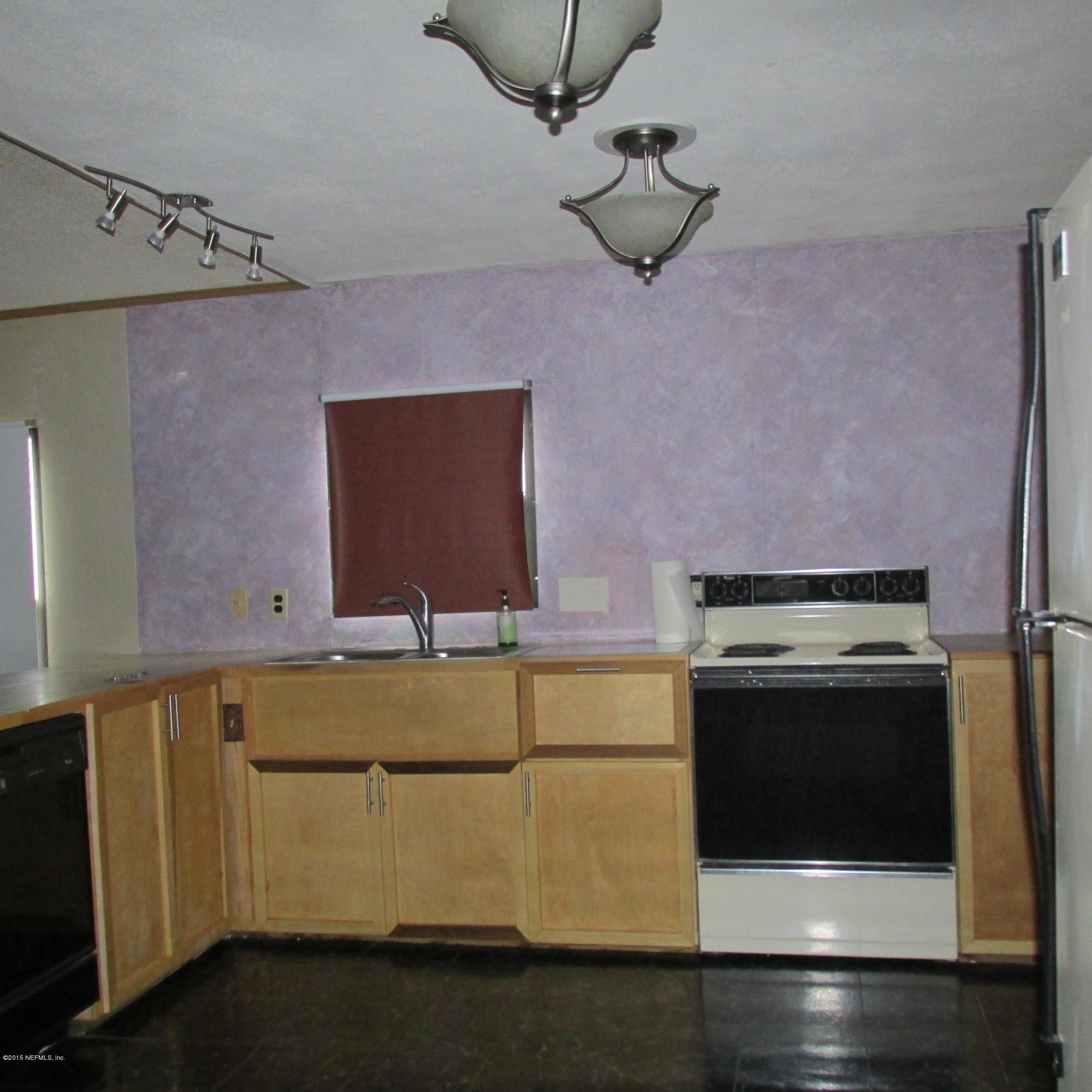 6841 Deer Springs Road Keystone Heights, FL 32656 - Photo 9 of 27 a kitchen with stainless steel appliances granite countertop a stove and a microwave