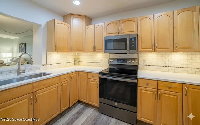 a kitchen with stainless steel appliances granite countertop a sink a stove a microwave and cabinets