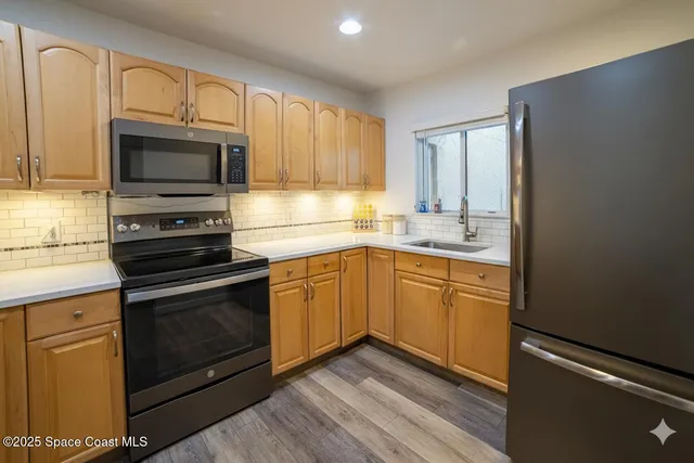 a kitchen with stainless steel appliances granite countertop a stove microwave and sink