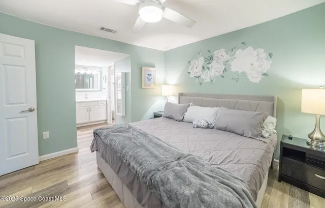 a spacious bedroom with a bed and a painting on the wall