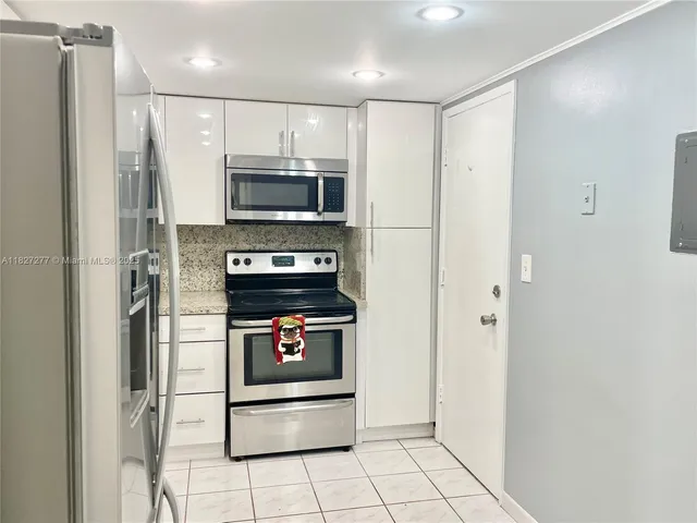 a kitchen with stainless steel appliances a refrigerator and a stove top oven