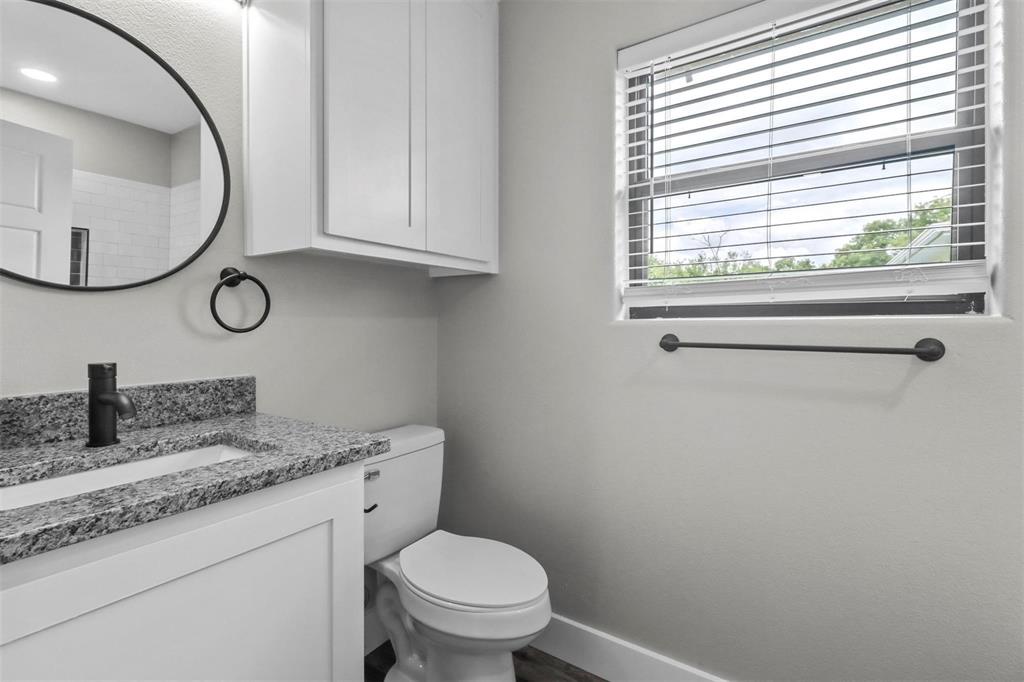 1401 South 5th Avenue, Unit 1401 Denison, TX 75021 - Photo 11 of 16 a bathroom with a granite countertop toilet sink and mirror