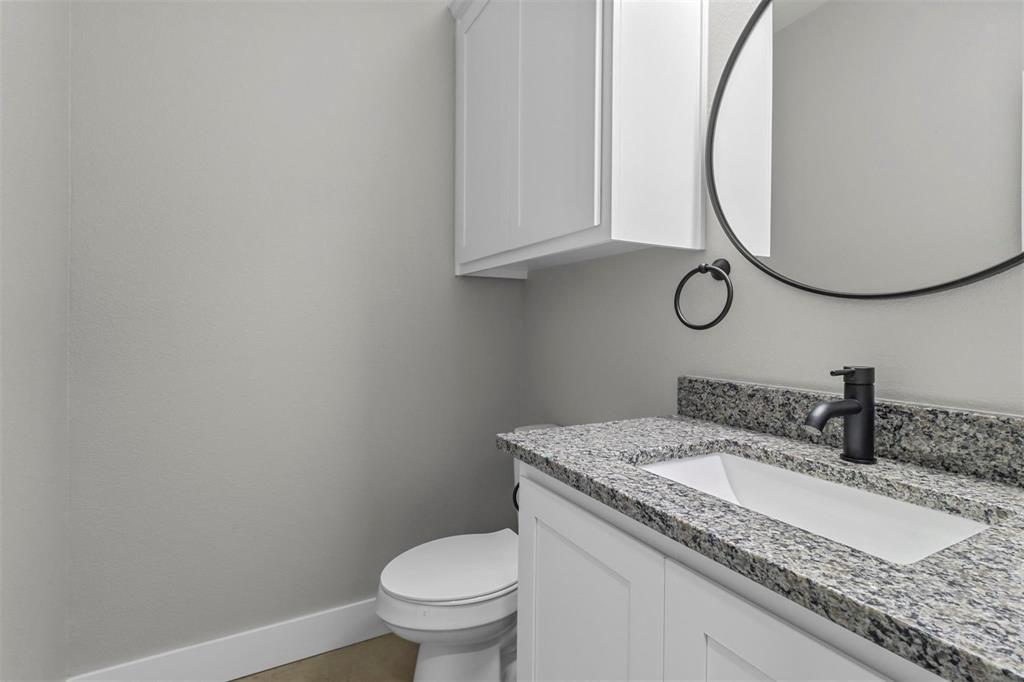 1401 South 5th Avenue, Unit 1401 Denison, TX 75021 - Photo 12 of 16 a bathroom with a granite countertop sink and a mirror