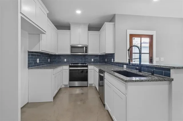 a kitchen with stainless steel appliances granite countertop a sink stove and cabinets