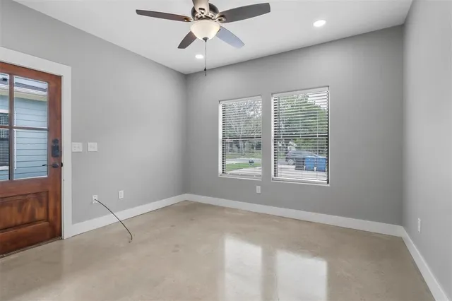 an empty room with fan and windows