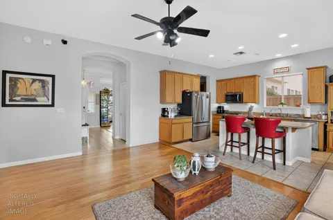 a living room with furniture kitchen view and a chandelier