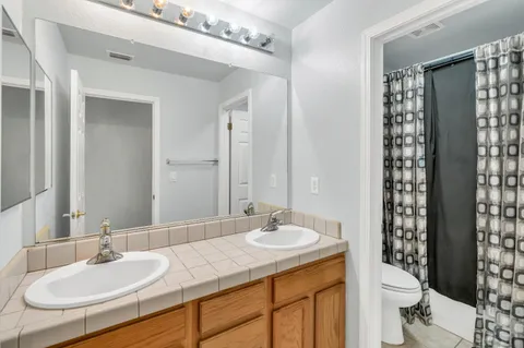 a bathroom with a granite countertop sink toilet and shower