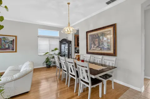 a dining room with furniture a chandelier and wooden floor