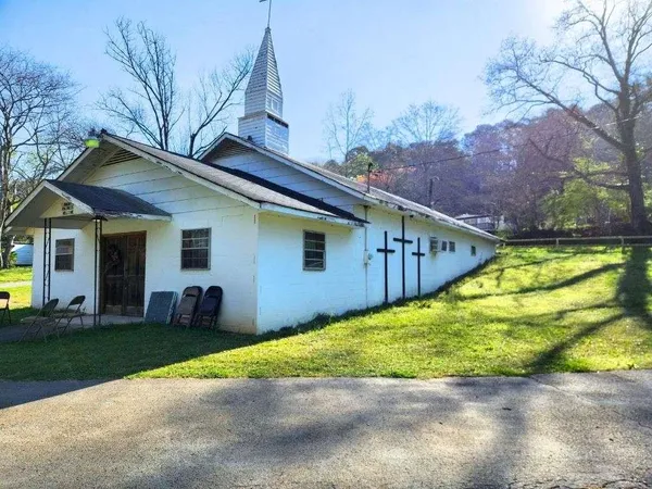 a view of a house with backyard and trees